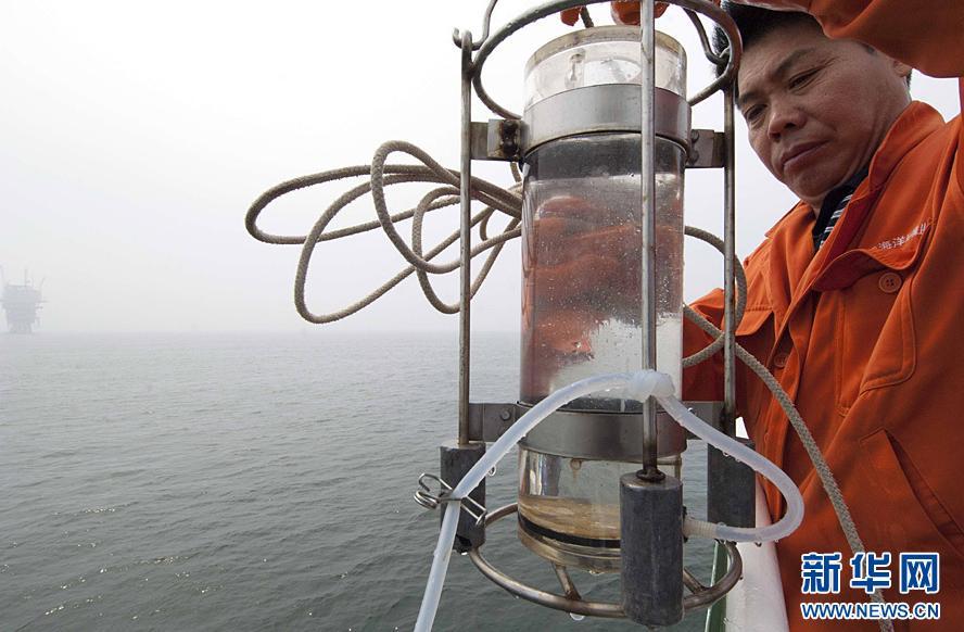 A scientist takes sample of the red tide in north China&apos;s Bohai Bay, July 15, 2011. The red tide has the length of about 2 sea miles and it locates near two oilfield platforms in Bohai Bay. The two oilfield platforms are estimated to have leaked 1,500 barrels of oil, or 240 cubic meters, following two oil spills last month, the operator ConocoPhillips said on Thursday. [Xinhua]