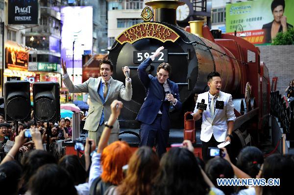 Cast members of 'Harry Potter and the Deathly Hallows - Part 2' James Phelps (C) and Olive Phelps (1st L), who portray the Weasley brothers, interact with fans in Hong Kong, south China, July 16, 2011. 