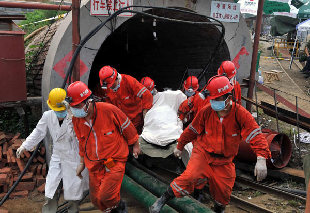 A body of a worker is carried out of a flooded iron core mine while two dozens are still trapped underground in Weifang city, East China's Shandong province, July 16, 2011. [Photo/Xinhua]