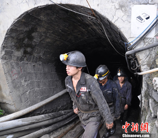 Rescue workers walk out of the  flooded Niupeng Mine, located in Pingtang County of Guizhou Province, on July 3. Rescue work in the coal mine has been terminated at 4 p.m. on July 16, 14 days after the flood trapped 23 workers underground.