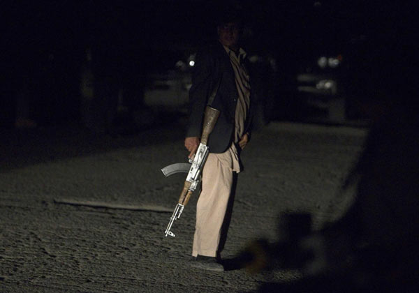 An Afghan security personnel in plain clothes keeps watch near the house of Jan Mohammad Khan, who was killed by insurgents, in Kabul July 17, 2011. [Photo/Agencies]