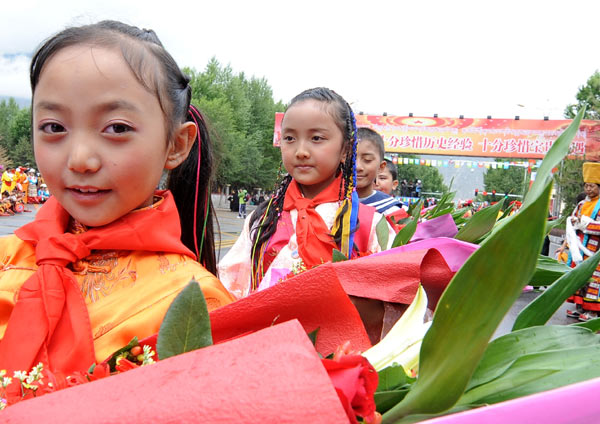 Students wait in Lhasa on Sunday to welcome a delegation from the central government led by Vice-President Xi JInping.