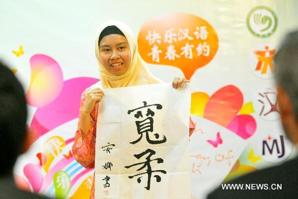 A contestant shows her calligraphy work during the Chinese language proficiency competition in Kuala Lumpur, Malaysia, on July 17, 2011. The Malaysian round of the Fourth 'Chinese Bridge' -- Chinese Proficiency Competition for High School Students took place here on Sunday with the participation of 16 contestants. 