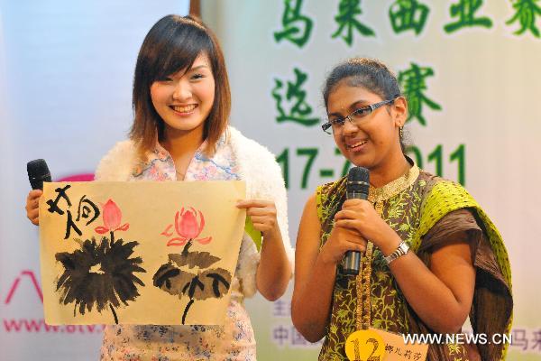 A contestant shows her water ink work during the Chinese language proficiency competition in Kuala Lumpur, Malaysia, on July 17, 2011. The Malaysian round of the Fourth 'Chinese Bridge' -- Chinese Proficiency Competition for High School Students took place here on Sunday with the participation of 16 contestants. 