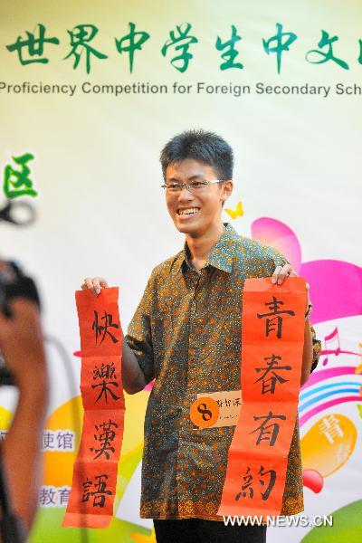 A contestant shows his calligraphy work during the Chinese language proficiency competition in Kuala Lumpur, Malaysia, on July 17, 2011. The Malaysian round of the Fourth 'Chinese Bridge' -- Chinese Proficiency Competition for High School Students took place here on Sunday with the participation of 16 contestants. 