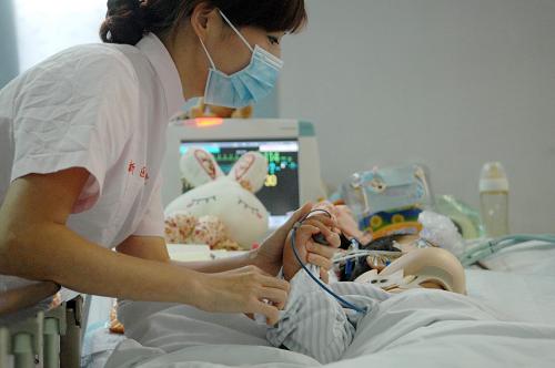 A nurse takes care of Niu Niu who lies in the intensive care unit (ICU) in Zhejiang Provincial Children&apos;s Hospital on July 11. The girl survived a fall from her 10th-floor home on July 2 and is recovering quickly.