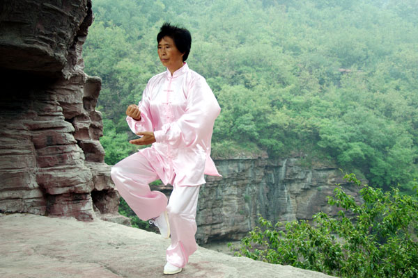 One of the masters practice Tai Chi in an open area on the mountains overlooking a deep valley. [Photo:CRIENGLISH.com] 