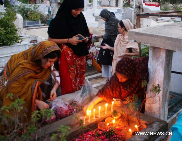 Muslims light candles and pray at a graveyard during the Shab-e-Barat Festival in Karachi, a port city in southern Pakistan, July 17, 2011. Muslims visit ancestral graveyards for the salvation of the departed souls and also believe that all sins will be forgiven by praying to Allah throughout the Shab-e-Barat night. (Xinhua Photo/Masroor)