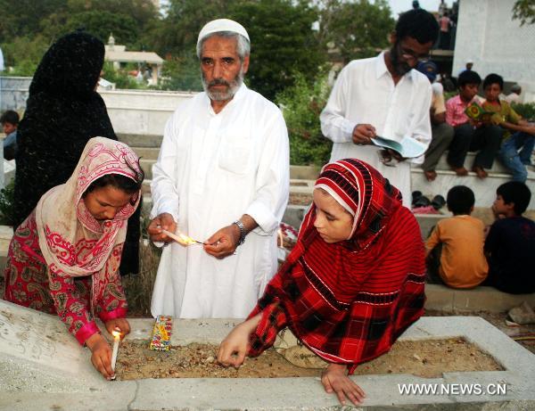 Muslims pray at a graveyard during the Shab-e-Barat Festival in Karachi, a port city in southern Pakistan, July 17, 2011. Muslims visit ancestral graveyards for the salvation of the departed souls and also believe that all sins will be forgiven by praying to Allah throughout the Shab-e-Barat night. [Xinhua Photo/Masroor]