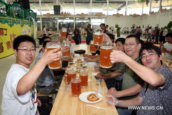 Visitors cheer as the first Beijing International Beer Festival opens in Beijing, capital of China, July 16, 2011. [Xinhua/Yang Le]