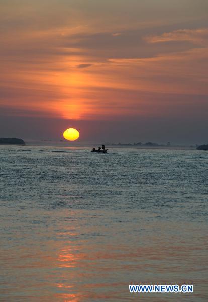 Fishermen trawl at sunrise in the waters of the Heixiazi Island near Fuyuan County, northeast China's Heilongjiang Province, July 18, 2011. [Xinhua/Wang Jianwei] 