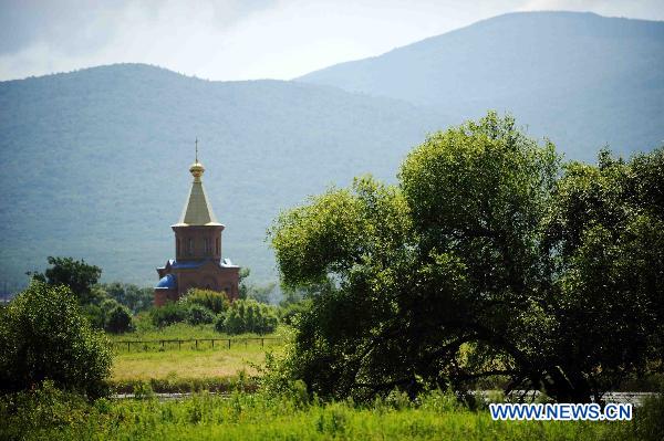 Photo taken on July 18, 2011 on the Chinese side of the Heixiazi Island in Fuyuan, northeast China's Heilongjiang Province shows an Orthodox church on the island's Russian side. [Xinhua/Wang Jianwei]