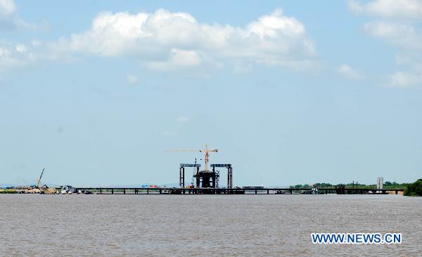 Photo taken on July 17, 2011 shows the Wusu Bridge that is under construction on the Heixiazi Island near Fuyuan County, northeast China's Heilongjiang Province. [Xinhua/Wang Jianwei]