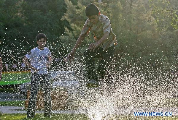 Children cool off in water in the northeastern city of Mashhad, Iran, July 18, 2011. A heatwave with the temperature of over 33 degrees Celsius swept the city. [Xinhua]