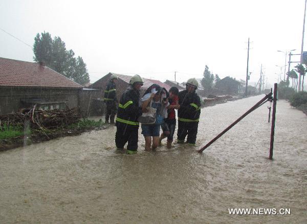 Firefighters help to rescue and transfer trapped residents on the waterlogged road at Daban town in Chifeng City, north China&apos;s Inner Mongolia Autonomous Region, July 18, 2011. Heavy rain hit the town on Monday, causing waterlog and interfering local traffic. No casualties had been reported by press time. 