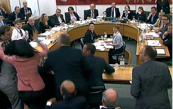 Wendi Deng lunges towards a man trying to attack her husband, News Corp Chief Executive and Chairman Rupert Murdoch, during a parliamentary committee hearing on phone hacking at Portcullis House in London July 19, 2011.