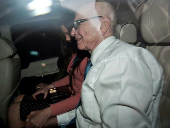 Murdoch and his wife hold hands as they are driven away from Westminster after the media tycoon gave evidence.
