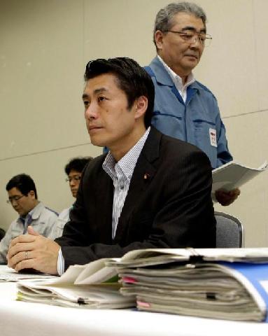 Toshio Nishizawa, president of Tokyo Electric Power Co., walks past Goshi Hosono, state minister for conclusion of the nuclear incident, during a joint press conference in Tokyo Tuesday, July 19, 2011.