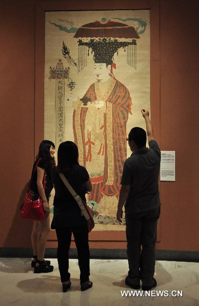 Visitors look at the exhibited Dunhuang art work in Shenzhen of south China's Guangdong Province, July 21, 2011. An exhibition of the Dunhuang art works was opened in Guanshanyue art gallery here on Wednesday, exhibiting multiple cultural relics, including paintings and scriptures. 