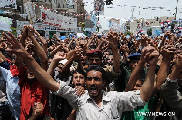 Anti-government demonstrators take part in a protest against government security agencies' attempt to assassinate the head of main opposition Islamic Islah Party Mohammed Abdullah al-Yadumi on Wednesday by firing on his car, in Sanaa, capital of Yemen, July 21, 2011. [Xinhua]