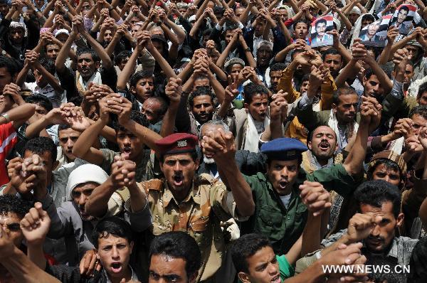 Anti-government demonstrators take part in a protest against government security agencies' attempt to assassinate the head of main opposition Islamic Islah Party Mohammed Abdullah al-Yadumi on Wednesday by firing on his car, in Sanaa, capital of Yemen, July 21, 2011. [Xinhua]