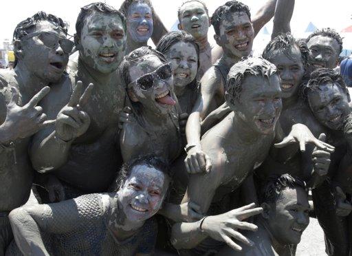 More than 130,000 visitors gathered in Boryeong on Thursday. Locals and tourists waded through the mud and played in 200 tons of the greyish goo in mud wrestling pots. Some of the revellers painted themselves with colored mud.