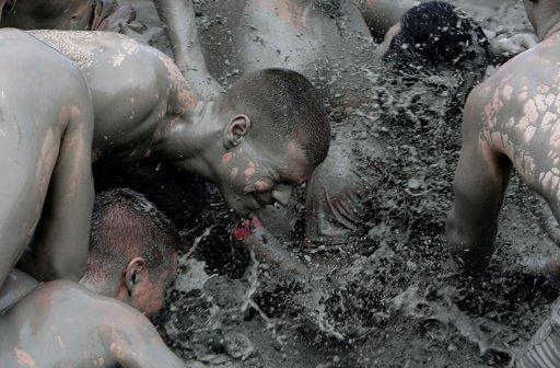 More than 130,000 visitors gathered in Boryeong on Thursday. Locals and tourists waded through the mud and played in 200 tons of the greyish goo in mud wrestling pots. Some of the revellers painted themselves with colored mud.