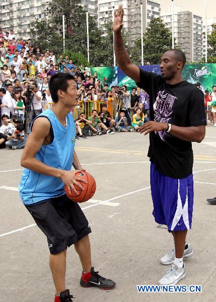 Kobe Bryant demonstrates layup skills to a young player in east China's Shanghai, July 21, 2011. As part of his Asian tour, NBA star Kobe Bryant met and gave instructions to young Chinese players in the final of a basketball contest Thursday in Shanghai.