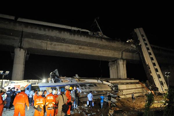 Rescue personnel work on the scene of the accident in Shuangyu Town in Wenzhou City of east China's Zhejiang Province, on July 24, 2011. The first four coaches of D301 and the 15th and 16th coaches of D3115 went off the line. [Xinhua]