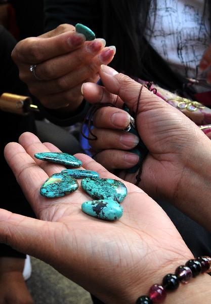 A tourist selects kallaite in a market in Lhasa, capital of southwest China's Tibet Autonomous Region, July 24, 2011. A large number of tourists poured into Tibet during the summer season, as the region is celebrating the 60th anniversary of its peaceful liberation. The region received 2.25 million tourists in the first half of this year, 24.8 percent more than the same period of last year. [Xinhua/Chogo]