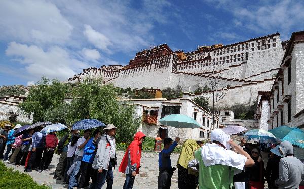 Tourists wait to visit the Potala Palace in Lhasa, capital of southwest China's Tibet Autonomous Region, July 24, 2011. A large number of tourists poured into Tibet during the summer season, as the region is celebrating the 60th anniversary of its peaceful liberation. The region received 2.25 million tourists in the first half of this year, 24.8 percent more than the same period of last year. (Xinhua/Chogo) 