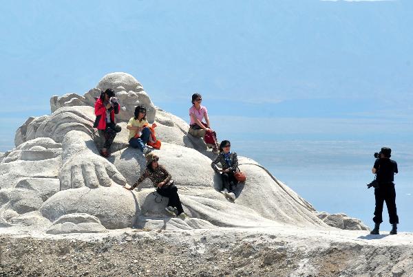  A tourist poses for photo at the Caka Salt Lake in Wulan County, northwest China's Qinghai Province, July 20, 2011. Tourist arrivals to Qinghai are picking up as the summer holiday season starts. (Xinhua/Wang Song) 