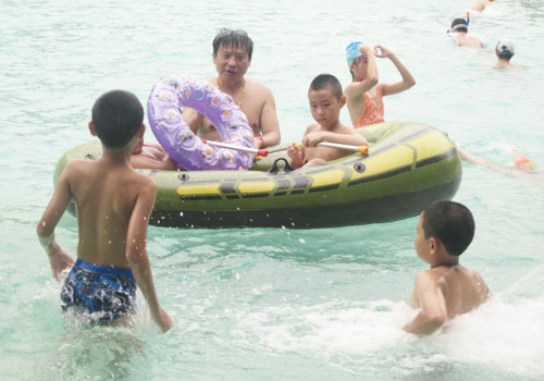 Swimmers play with an inflatable raft at Beijing's Qingnianhu Water Park. [Photo:CRIENGLISH.com] 