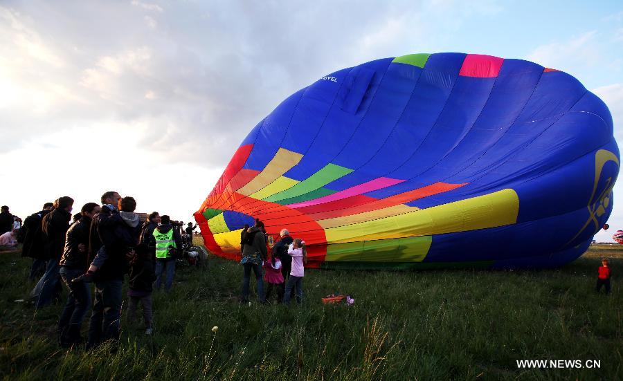 Participants prepare to fly a balloon during the Lorraine World Hot-Air Balloons Festival (LMAB) in the northeast France's city of Chambley, July 24, 2011. The LMAB runs from July 22 to 31, 2011. [Xinhua/Gao Jing]