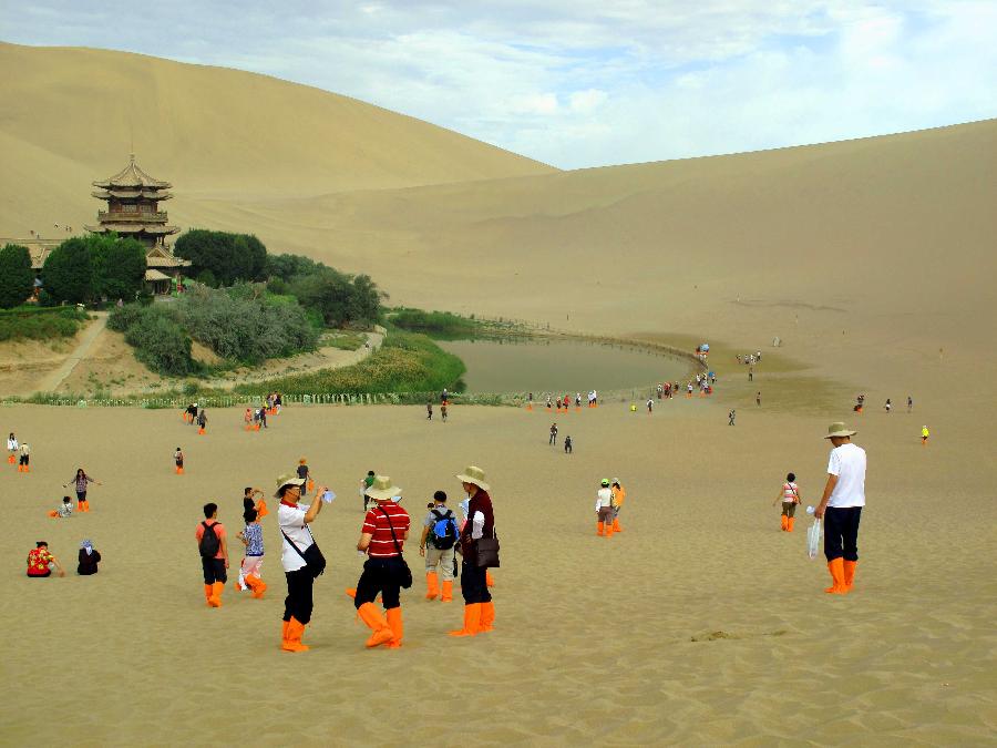 Photo taken on July 25, 2011 shows the rich oasis scenery zone of Yueya Spring (Crescent Spring) and the adjacent Mingsha Mountain Dunes (Singing-Sand Dunes) coexisting in Dunhuang City, northwest China's Gansu Province. 