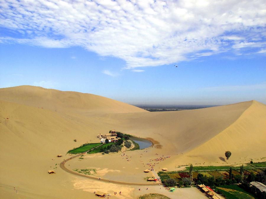 Photo taken on July 25, 2011 shows the rich oasis scenery zone of Yueya Spring (Crescent Spring) and the adjacent Mingsha Mountain Dunes (Singing-Sand Dunes) coexisting in Dunhuang City, northwest China's Gansu Province. 