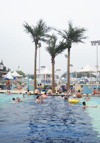 Swimmers revel in the tropical atmosphere at Chaoyang Park's beach. [Photo:CRIENGLISH.com]