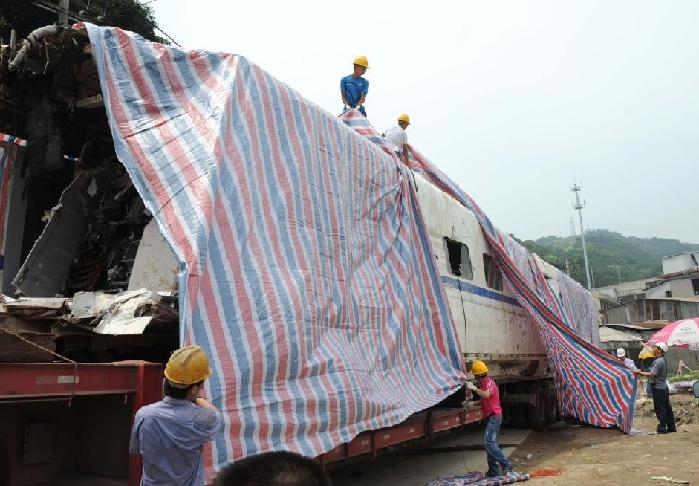 Mangled pieces of two derailed trains are loaded on to trucks at the derail site near the city of Wenzhou in East China's Zhejiang province on early Tuesday morning, 2011.