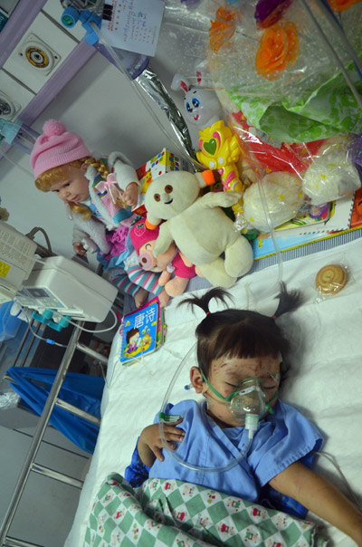Xiang Weiyi, the last passenger rescued from the Wenzhou train crash, sleeps in a hospital bed in Wenzhou on Tuesday, July 26, 2011. At the head of the bed are toys given her by local residents.