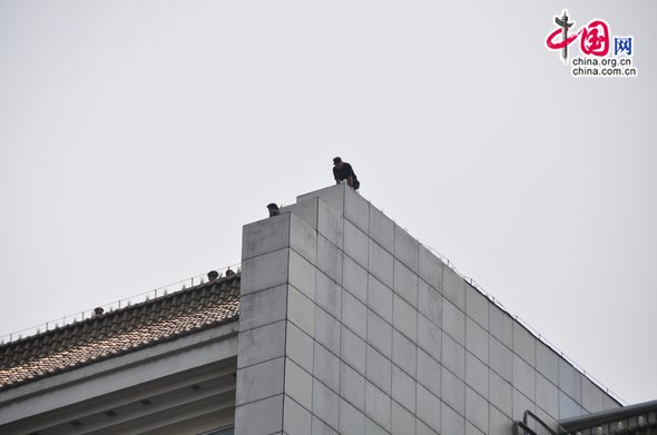 The man (L1) threatens to jump off the roof of Parkson Plaza, at Fuxingmen, central Beijing. [Maverick Chen / China.org.cn] 