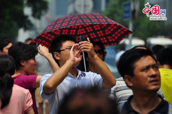 Some bystanders show concern, taking photos of the man and and reporting the incident in posts on microblogging sites. [Maverick Chen / China.org.cn]