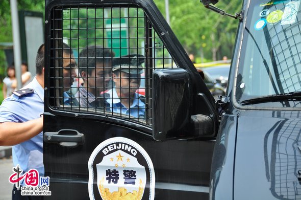 The man is escorted to the police vehicle after a brief questioning. [Maverick Chen / China.org.cn]