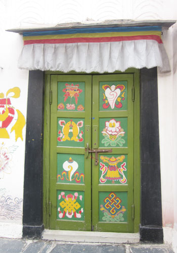 Colorfully-painted doors and windows line the 'Bajiao Street,' modeled after its namesake in Lhasa, in the China Ethnic Culture Park's Tibetan village. [Photo:CRIENGLISH.com]