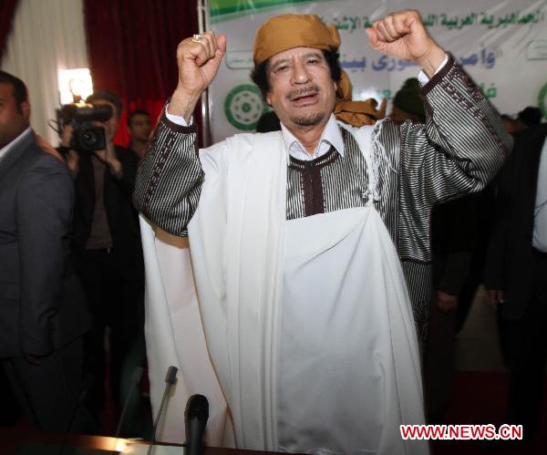 Libyan leader Muammar Gaddafi gestures to his supporters during a ceremony marking the 34th anniversary of the launch of the Popular Committees in Tripoli, capital of Libya, March 2, 2011. [Hamza Turkia] 
