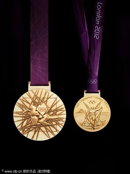 Two sides of 2012 Olympic Gold medal next to a twenty pence coin during a photocall at the London Organising Committee of the Olympic Games 2012 in Canary Wharf, London.