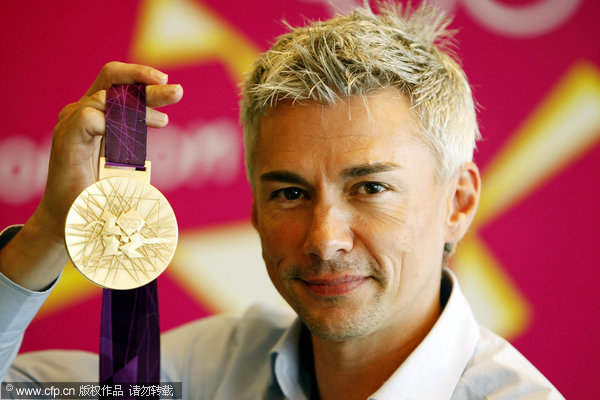 Former British Triple Jumper Jonathan Edwards with the 2012 Olympic Gold Medal during a photocall at the London Organising Committee of the Olympic Games 2012 in Canary Wharf, London.