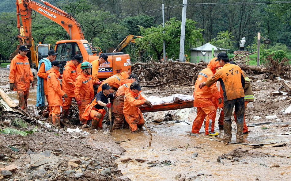 Rescue workers work at the scene of a landslide in Chuncheon, Gangwon province, South Korea, July 27, 2011.