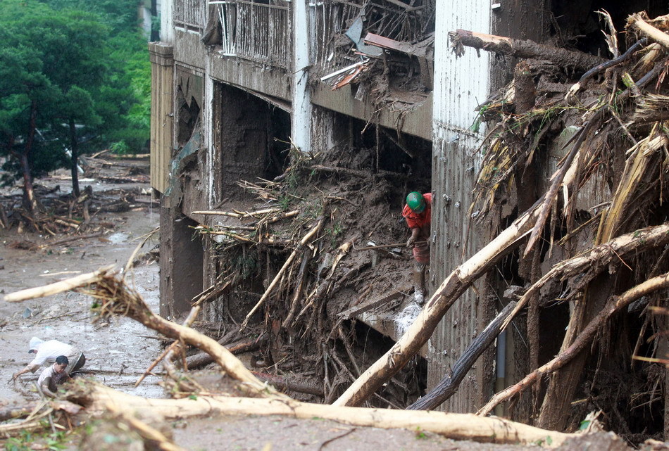 Rescue workers work at the scene of a landslide in Chuncheon, Gangwon province, South Korea, July 27, 2011.