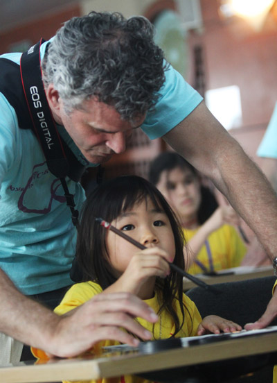 Born in the Guangxi Zhuang autonomous region, 6-year-old Sascha Friend learns calligraphy in Beijing, July 27, 2011, with the help of her adoptive father, Russell Friend, who is from California.