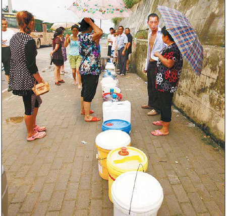 Residents of Mianyang, Sichuan province, line up to get spring water on Thursday. It took two hours for the dripping spring water to fill each bucket. [China Daily] 